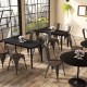 Tolix style stackable metal dining chairs with wood seats in a cafe setting, featuring ergonomic design and sturdy.